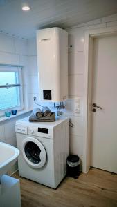 a white washer and dryer in a kitchen at Ferienwohnung Dennis in Nordleda +7 photos