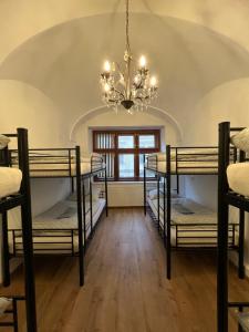 a room with four bunk beds and a chandelier at Cassovia Hostel in Košice +29 photos