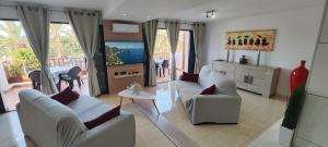 a living room with chairs and a television and a table at BAMBÙ in Arona