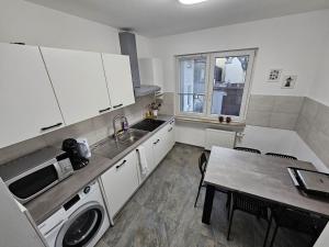 a kitchen with a sink and a table with a washing machine at Einzelzimmer für bis zu 2 Personen - 4 OG in Duisburg