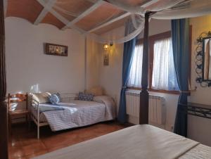 a bedroom with a bed and a couch and a window at Masía Can Janàs in Lliçà d'Amunt