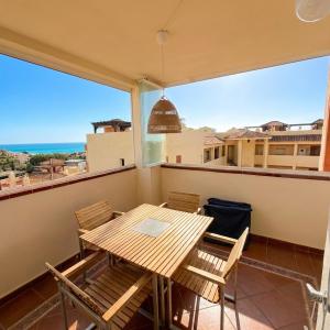a table and chairs on a balcony with a view of the ocean at Casa Ricardo Penthouse in Sitio de Calahonda