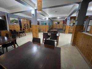a dining room with wooden tables and chairs at Yolmo Hotel in Gorkhe
