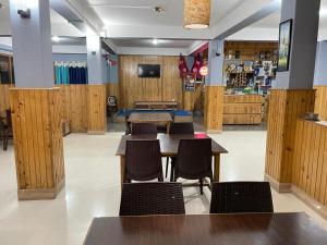 a restaurant with wooden walls and tables and chairs at Yolmo Hotel in Gorkhe