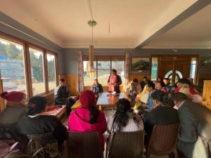 a group of people sitting around a table in a room at Yolmo Hotel in Gorkhe