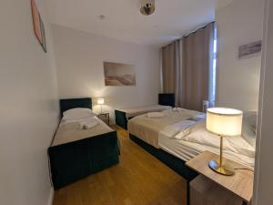 a bedroom with two beds and a lamp on a table at Munich Apartment 110 qm with 3 Bedrooms very cetral location 1 to 10 Guests in Munich +22 photos