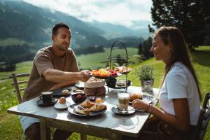 a man and a woman sitting at a table with food at Gailerhof Boutique Hotel B&B Dolomites in Monguelfo +197 photos