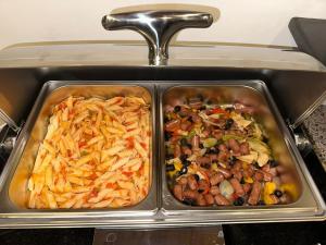 two metal trays filled with different types of food at Petra Sky Hotel in Wadi Musa