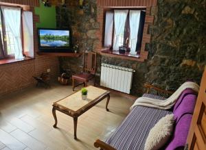 a living room with a couch and a table and a tv at El BurbyI in Somo