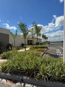 a parking lot with palm trees and a building at Doce lar in Pouso Alegre