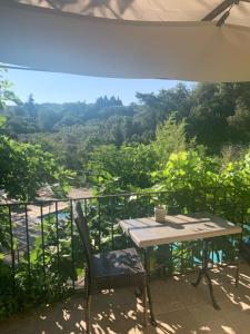 a table and chairs on a balcony with a view at Les Vergers des Maures in La Garde-Freinet