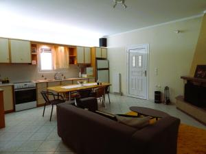 a living room and kitchen with a couch and a table at Menelais Guesthouse in Khotoússa +7 photos
