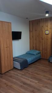 a bedroom with a bed and a cabinet in it at Chmurka in Bęczków