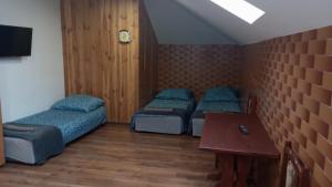a room with three beds and a table in it at Chmurka in Bęczków