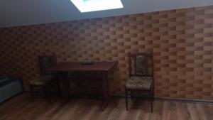 a room with two chairs and a table and a brick wall at Chmurka in Bęczków