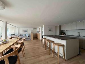 a kitchen and living room with a table and chairs at Villa with spectacular sea view in Öckerö
