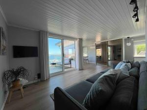 a living room with a blue couch and a view of the ocean at Villa with spectacular sea view in Öckerö