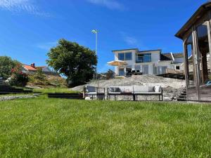 a couple of benches in the grass in front of a house at Villa with spectacular sea view in Öckerö