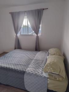 a small bedroom with a bed with a window at Rincon de Olivares in Los Olivares