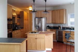 a kitchen with wooden cabinets and a stainless steel refrigerator at Moosedance 2 bedroom suite, beautiful views in Anchorage +7 photos