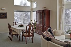 a dining room with a table and chairs and a couch at Moosedance 2 bedroom suite, beautiful views in Anchorage
