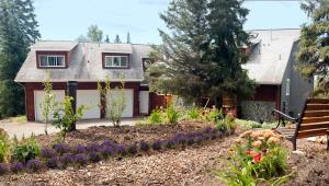 a garden in front of a house with a bench at Moosedance 2 bedroom suite, beautiful views in Anchorage