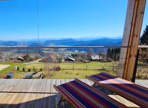 a deck with two chairs and a view of a field at Zimmer mit Aussichthochzehn in Himmelberg