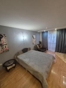 a bedroom with a large bed and a couch at Апартаменты in Izmail