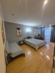 a bedroom with a large bed and a couch at Апартаменты in Izmail +6 photos