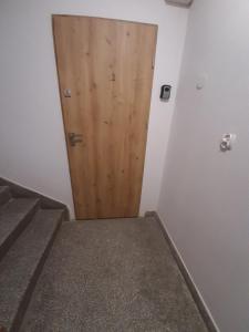 a wooden door in a room with stairs at Apartament 12 in Zwardoń +5 photos