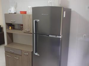 a stainless steel refrigerator in a kitchen at COBERTURA Duplex com Visao do Mar, Village das ondas in Piúma