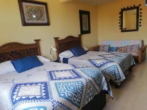 a bedroom with two beds with blue and white blankets at Beautiful condo a few steps to sea in Cancún
