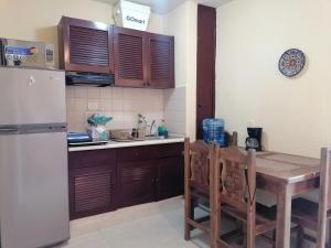 a kitchen with a table and a refrigerator at Beautiful condo a few steps to sea in Cancún