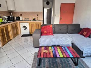 a living room with a couch and a table at Au Franciscea, climatiseurs, centre ville, sud in Saint-Louis