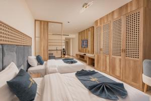 a hotel room with three beds with blue pillows at Golden Pillar Hotel in Aqaba +89 photos