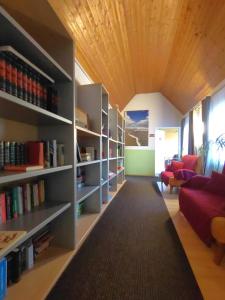 a living room with a red couch and bookshelves at Hotel Smart-Inn in Erlangen