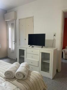 a bedroom with a white dresser with a television on it at EL RELOJ in Chascomús