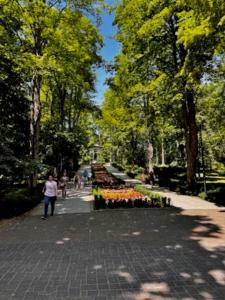 a woman walking down a path in a park at Willa Piastowska in Polanica-Zdrój