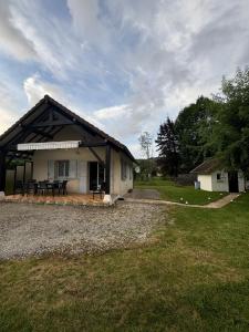 a barn with a table and chairs in a yard at L'Ains'tant présent in Sirod