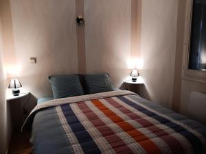 a bedroom with a bed with two lamps on both sides at L'Ains'tant présent in Sirod