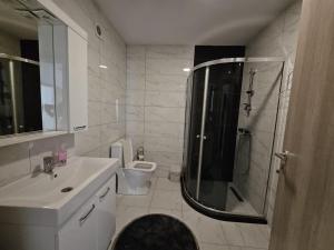 a bathroom with a shower and a sink and a toilet at Matin apartment in Ferizaj +10 photos