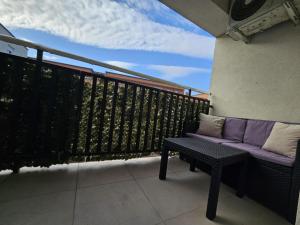 a balcony with a purple couch on a balcony at Matin apartment in Ferizaj