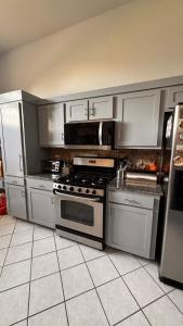 a kitchen with stainless steel appliances and white cabinets at Andrei's nest in Oklahoma City
