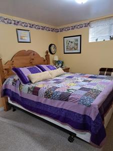 a bedroom with a bed with a purple quilt at Carrousel Bed & Breakfast in Cayuga