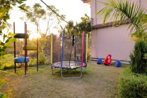 a swing set in a yard with at Corbett Nature Walk - Forest View Swimming Pool Retreat in Rāmnagar +56 photos
