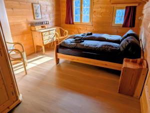 a bedroom with two beds in a wooden cabin at Maisonette-Wohnung in Rueras bei Sedrun - 200m zum Bahnhof - Perfekt für Ski & Ausflüge in Rueras