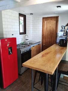 a kitchen with a red refrigerator and a wooden table at Mini cabaña in Pucón