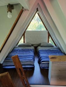 two beds in a loft with a window at Mini cabaña in Pucón