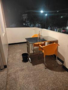 a table and two chairs in a room with a table and a table at Hotel Priyanka - 750 metres from nakki lake Near Bus Stand in Mount Ābu