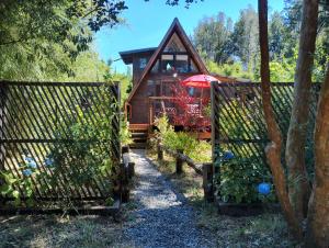 a cabin in the woods with two gates at Mini cabaña in Pucón